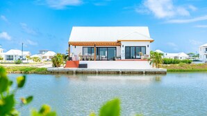 Una casa moderna con un ampio patio, una piscina e un cielo azzurro limpido.