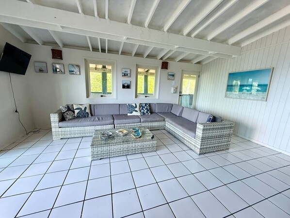 A room with a sectional sofa, a glass coffee table, and a painting on the wall. - Apto 4B Flamenco Beachfront Villas with Ocean View (Flamenco)