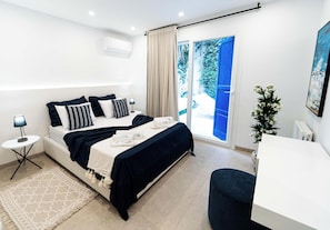 Un dormitorio moderno con cama, mesita de noche y vistas a un balcón.