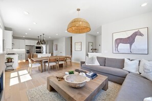 Ein modernes Wohnzimmer mit Sofa, Couchtisch und Essbereich.