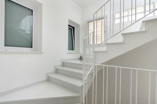 A white staircase with a railing, a window, and a door. - Apartment 'Palazzo Tilde - 2A' with Sea View, Wi-Fi and Air Conditioning (Marsala)