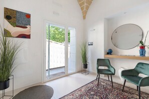 A modern interior with a large sliding glass door, a potted plant, a round mirror, and a patterned rug. - Apartment 'Palazzo Tilde - 2A' with Sea View, Wi-Fi and Air Conditioning (Marsala)