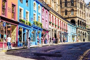 A cobblestone street with colorful buildings, a museum, and people walking. - City Centre Sleeps 8 Walking Distance to Castle (Edinburgh)