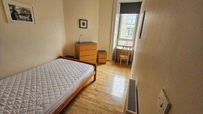 A bedroom with a bed, a dresser, a chair, and a window. - City Centre Sleeps 8 Walking Distance to Castle (Edinburgh)
