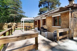 A wooden cabin with a patio area, outdoor seating, and a pergola. - Holiday Home 'Gite 5 De L'Orée Du Bois' with Lake View, Wi-Fi and Air Conditioning (Thenon)