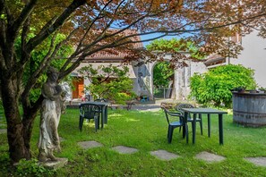 Ein Innenhof mit Steinstufen, grünem Rasen und Gartenmöbeln.