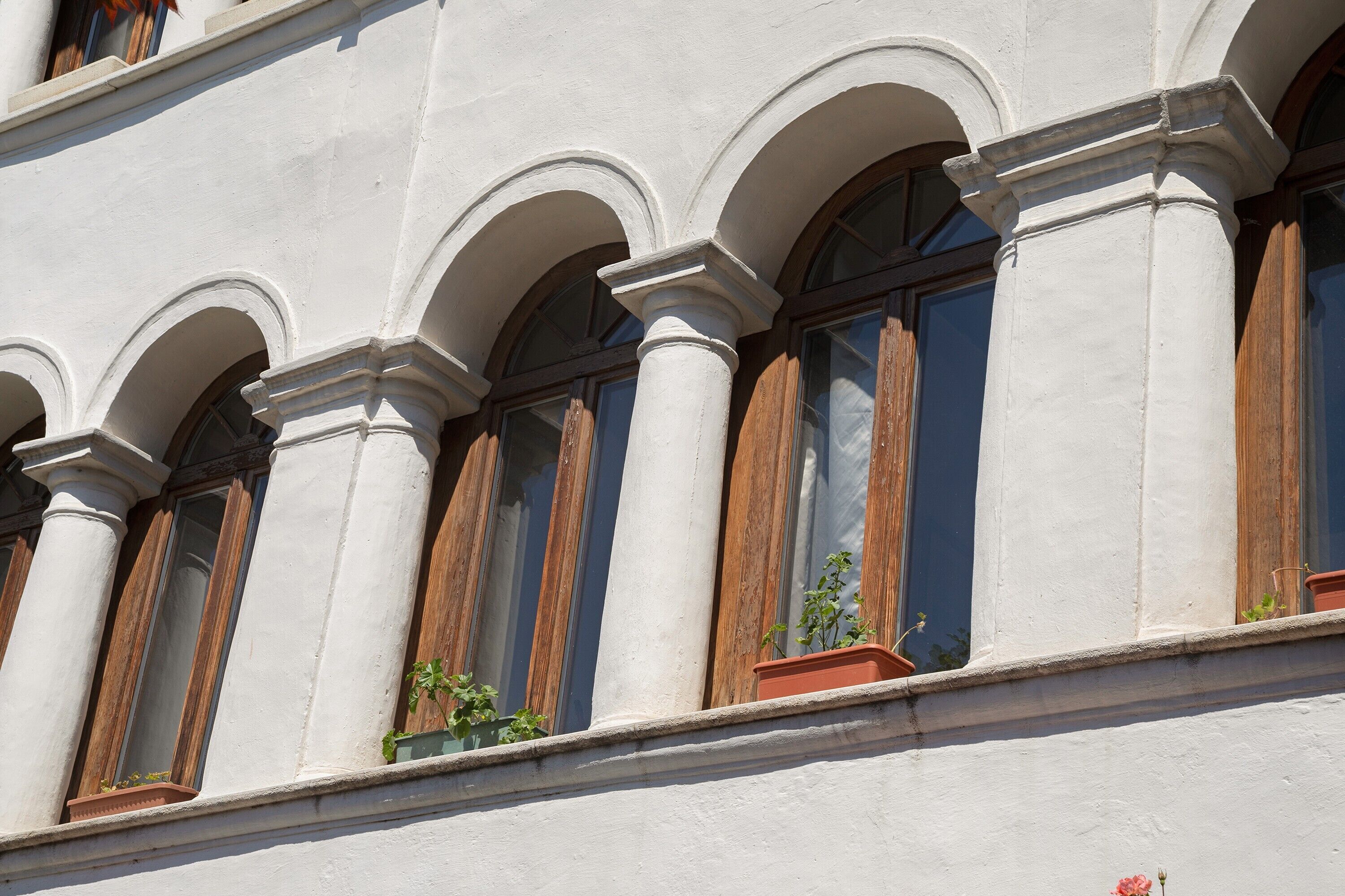Une façade d’immeuble ornée de fenêtres en arc et de colonnes.