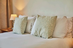 A neatly made bed with white linens and two pillows with a green leafy pattern. - Host & Stay | The Beach (Filey)