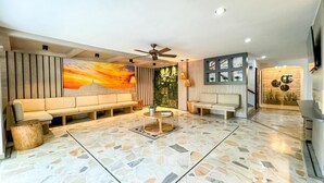 A spacious living area with a sofa, coffee table, and a ceiling fan. - HOTEL VALLADOLID (Santa Marta)