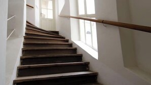 A staircase with wooden steps and a handrail, leading to a door at the top.