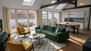 A modern living room with a green sofa, yellow armchair, and a round coffee table.