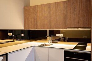 Eine moderne Küche mit Kochinsel, eingebauten Geräten und einer Wand in Holzoptik.