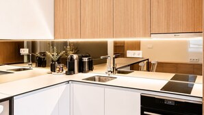 Una cucina moderna con piano cottura integrato, lavello e zona pranzo con tavolo e sedie.