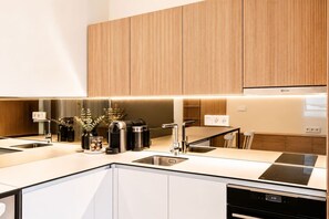 Eine moderne Küche mit Einbauherd, Spüle und Essbereich inklusive Tisch und Stühlen.