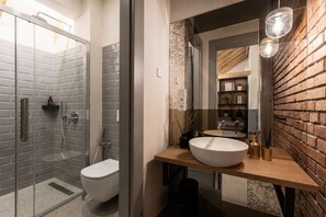 Ein modernes Badezimmer mit einer Duschkabine aus Glas, einer weißen Toilette und einem hölzernen Waschtisch mit einem großen Becken.