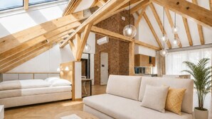 Een moderne loft met zichtbare houten balken, een bakstenen muur en een groot raam.