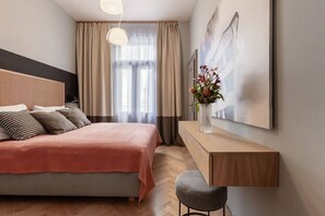 Ein modernes Schlafzimmer mit einem Bett, einem Nachttisch, einem Sessel, einem Schreibtisch und einem Fenster mit Vorhängen.