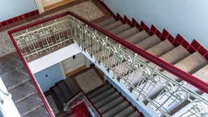 A multi-level staircase with ornate metal railings and red accents. - Stylish Residence in Parkside Vinohrady (Prague 2)