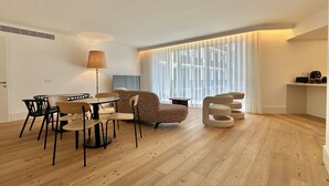 Una sala de estar moderna con una mesa de comedor, sillas, un sofá y una lámpara.