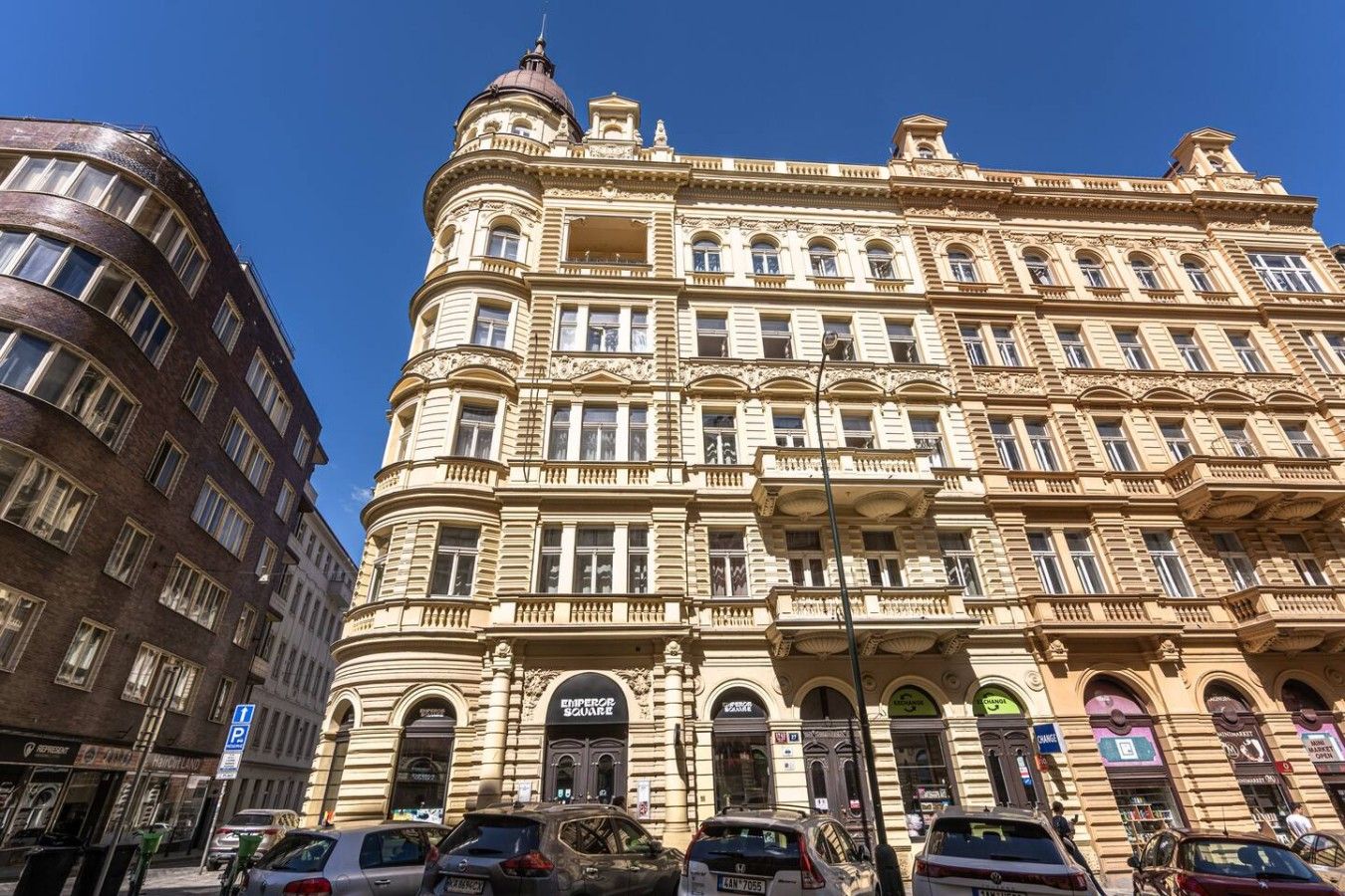A historic building with a prominent corner entrance, multiple windows, and a sign reading 'EMPEROR SQUARE'.