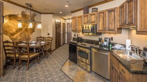 A kitchen with wooden cabinets, a stainless steel refrigerator, a microwave, and a coffee maker.