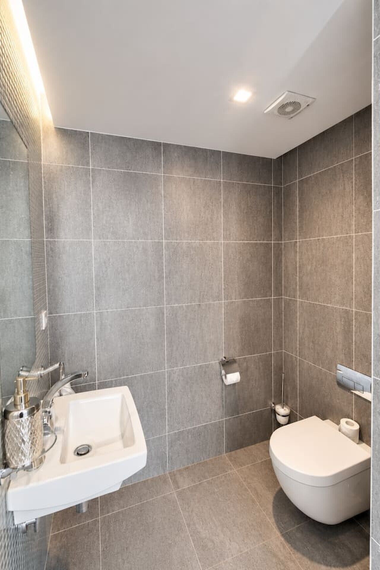 Ein modernes Badezimmer mit freistehender Waschtisch, Toilette und separater Duschkabine.