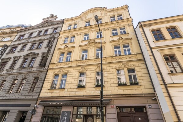 Ein mehrgeschossiges Gebäude mit Restaurant im Erdgeschoss, aufwändigem architektonischen Verzierdekor und einer Straßenlaterne.