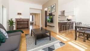 A modern living room with a sofa, coffee table, and dining area with chairs. - Comfortable Two-Bedroom Residence in the Heart of Prague (Prague 1)
