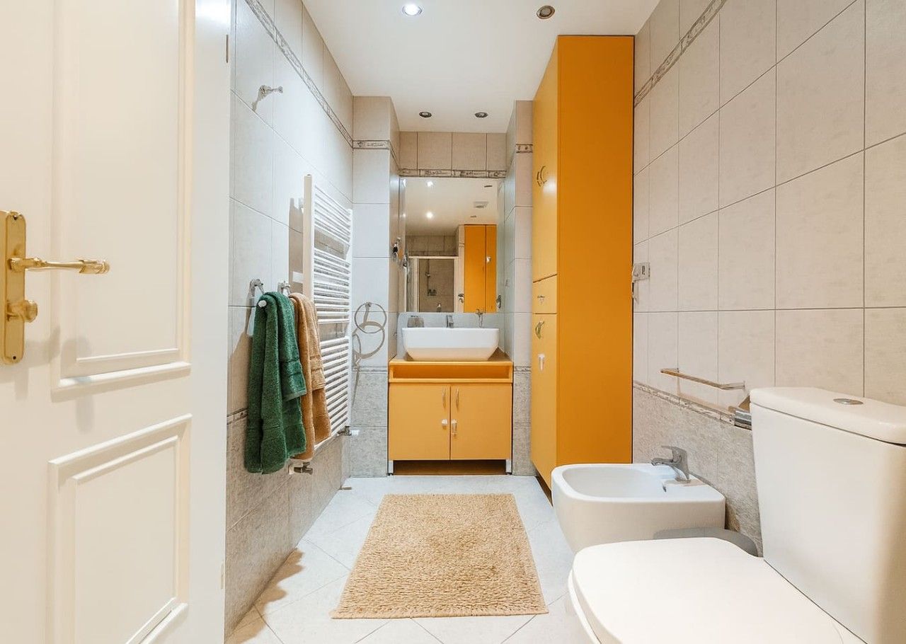 A modern bathroom with a bathtub, toilet, and sink.