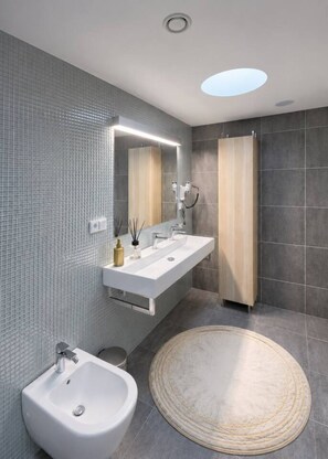 A modern bathroom with a large mirror, two sinks, a bidet, and a round rug. - Urban Oasis Karlín – Spacious Retreat by the River (Prague 8)
