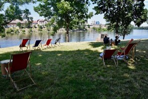 Entorn de llac amb seients de gespa i taula de dinar, que suggereix una zona de menjador.