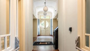 A hotel hallway with a carpeted floor, a door at the end, and a light fixture above. - Cozy Attic Loft in Prime Location (Prague 2)