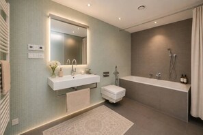 Ein modernes Badezimmer mit einem Doppelwaschtisch, einer Toilette, einer Badewanne und einer Dusche.
