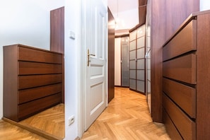 A hallway with wooden paneling, a white door, and a herringbone-patterned floor. - Top flat close to Wenceslas square with parking (Prague 2)