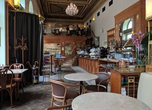 Ein Restaurant mit Barbereich, Sitzgelegenheiten und einer Treppe zu einer oberen Ebene.