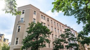 A multi-story building with a flat facade, large windows, and a corner balcony.