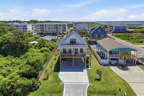 Ein Wohngebiet mit einem Haus, das eine Veranda, eine Garage und einen Einfahrtsweg hat.