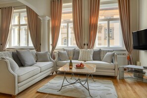 Ein modernes Wohnzimmer mit einer Sofagarnitur, einem Couchtisch und einem Flachbildfernseher.