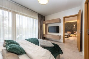 Ein modernes Hotelzimmer mit Bett, Fernseher und Blick nach außen.