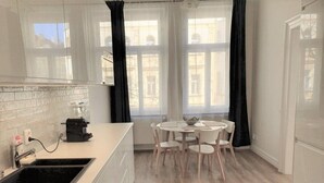 Eine moderne Küche mit Spüle, Arbeitsplatte und Essbereich mit Stühlen.