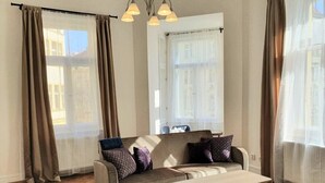 Ein Wohnzimmer mit einer Couch, einem Couchtisch und einem gemusterten Teppich.