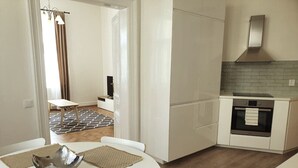 Eine moderne Küche mit weißen Schränken, einem eingebauten Ofen und einer Backstein-Spritzschutzwand.