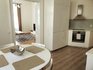 A modern kitchen with white cabinets, a built-in oven, and a brick backsplash.