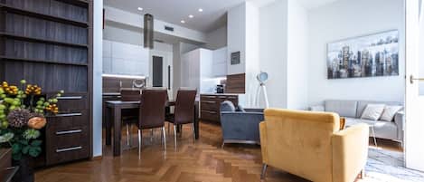 A modern living space with a dining area, sofa, and a cityscape painting.