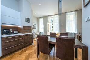 Eine moderne Küche mit Essbereich, Holzboden und Blick auf die Stadt.