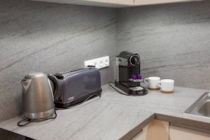 Eine Küche mit Toaster, Kaffeemaschine und Wasserkocher auf der Arbeitsfläche.