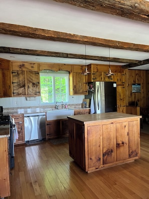 A kitchen with wooden cabinets, a stainless steel refrigerator, and a large island. - Spacious 6-bedroom house in Killington- Biking and Hiking Getaway (Killington)