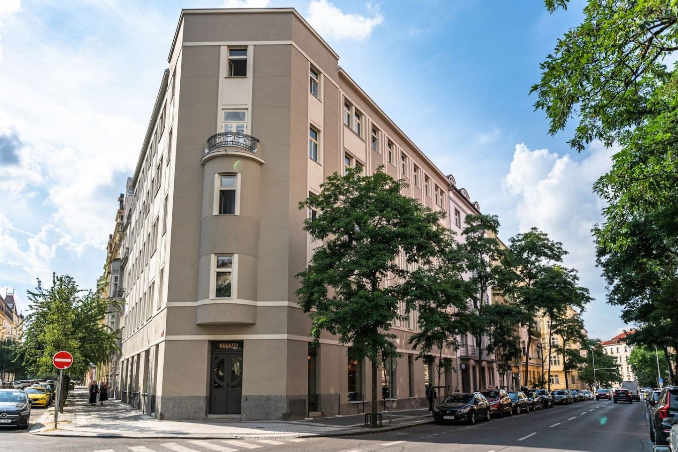 Un edificio de varios pisos con fachada plana, entrada a nivel de calle y un balcón visible en el segundo piso.