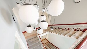 A staircase with a handrail, carpeted steps, and a white wall. - Luxury Two-Bedroom Residence in Vinohrady (Praha 2)