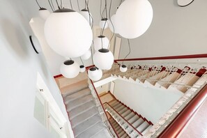 Eine Treppe mit Handlauf, mit Teppich belegten Stufen und einer weißen Wand.